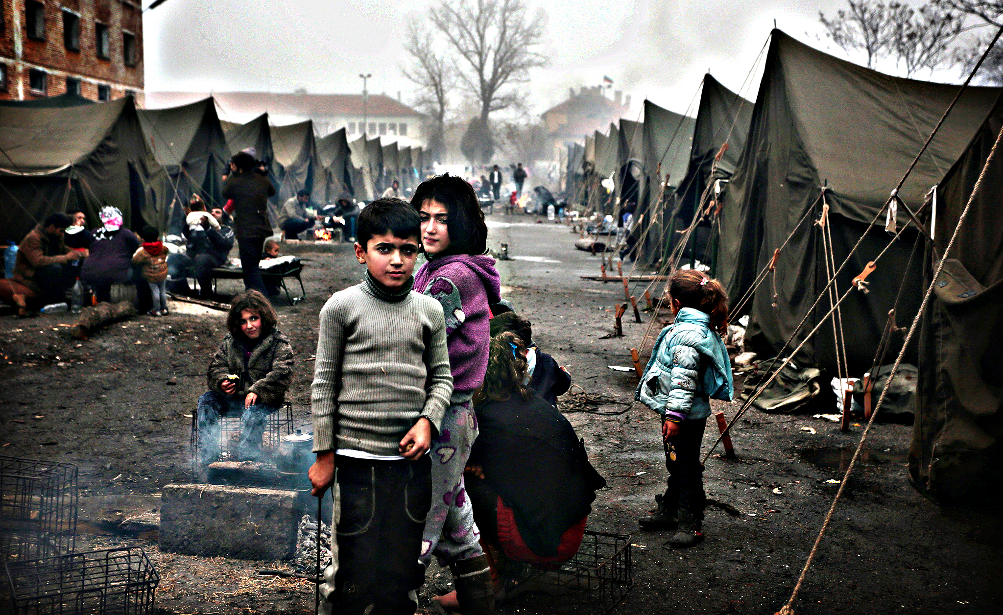 Syrian children try to stay warm near an open fire in front of their unheated tents in a refugee camp in the town of Harmanli, Bulgaria, Thursday, Nov. 21, 2013. Thousands of Syrian and other refugees from the Middle East, Asia and Africa, who find enough courage to make a dangerous journey from their war-ravaged states, often end up in the crammed settlements in the Balkans, including Bulgaria, Greece or Serbia, after being caught on the borders of wealthy Western European nations for attempting to cross illegally.