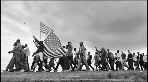 The Selma to Montgomery March for voting rights was the largest and most significant march of civil rights history. Here marchers and flags cross the horizon. In the air, a US Army reconnisance plane on the lookout for threats to the march.